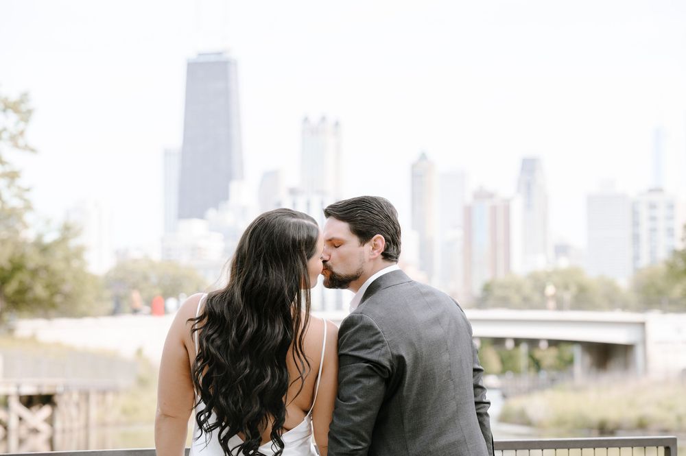 A couple shares an intimate moment while overlooking the Chicago skyline on an overcast day.