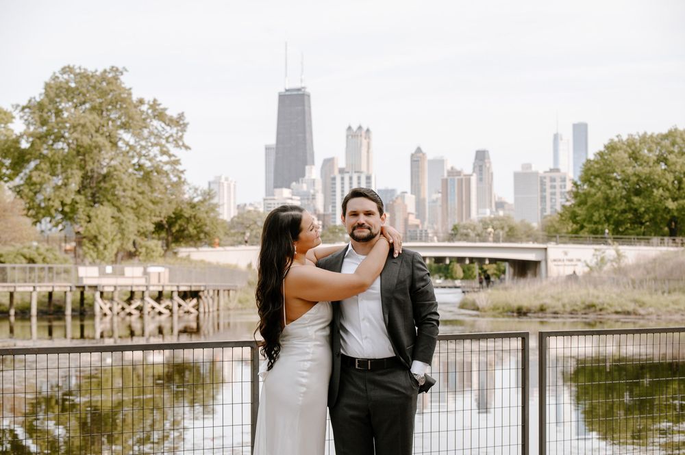 A couple shares a romantic moment at Lincoln Park with the Chicago skyline in the background.