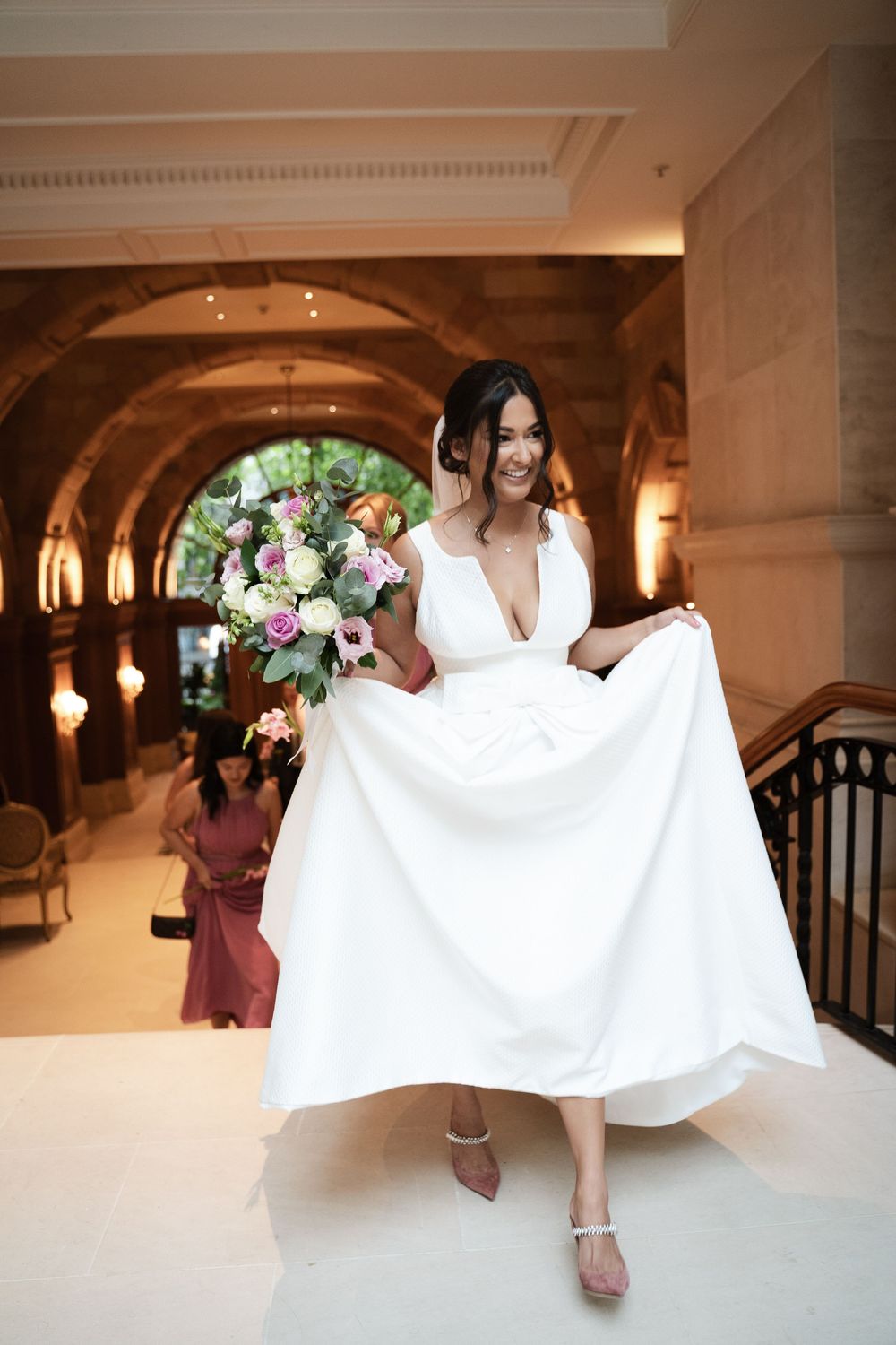 Bride's flowing white dress twirling in an elegant indoor venue with arched doorways.