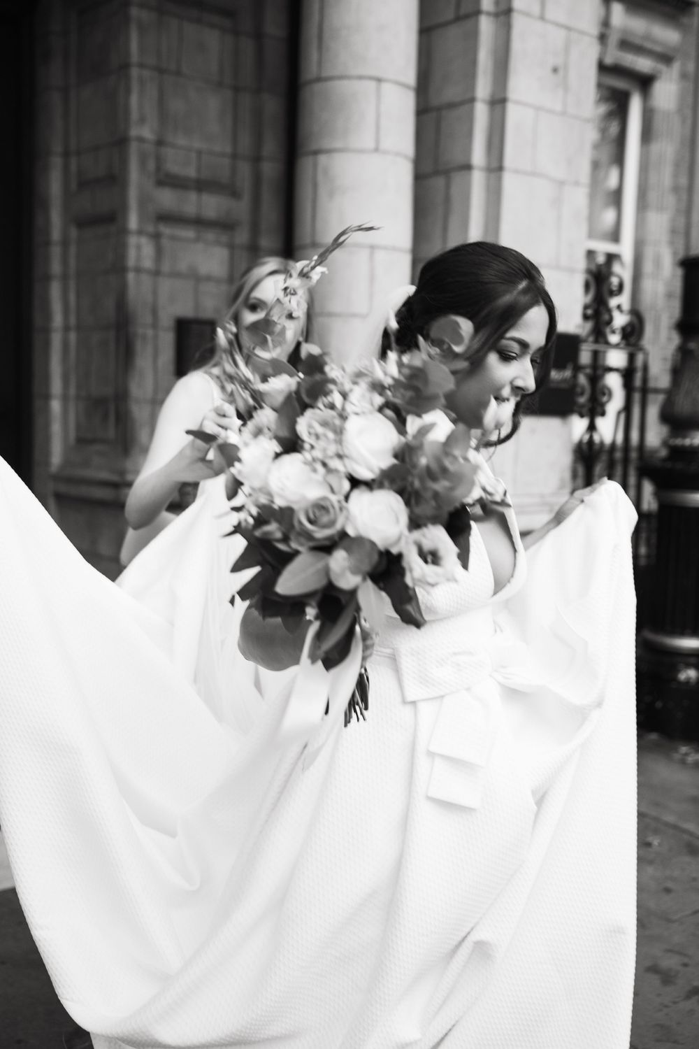 Black and white detail shot of wedding dress billowing with floral accents.