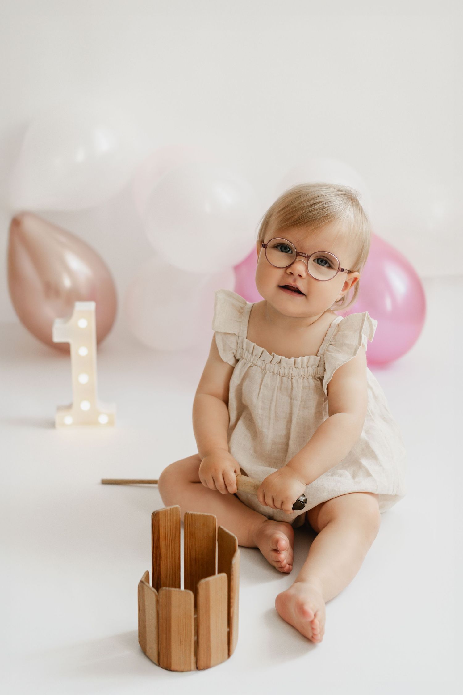 Kleines Mädchen beim Geburtstagsfotoshooting im Fotostudio Stockerau, natürliches Geburtstagsfoto, Cake-Smash-Foto