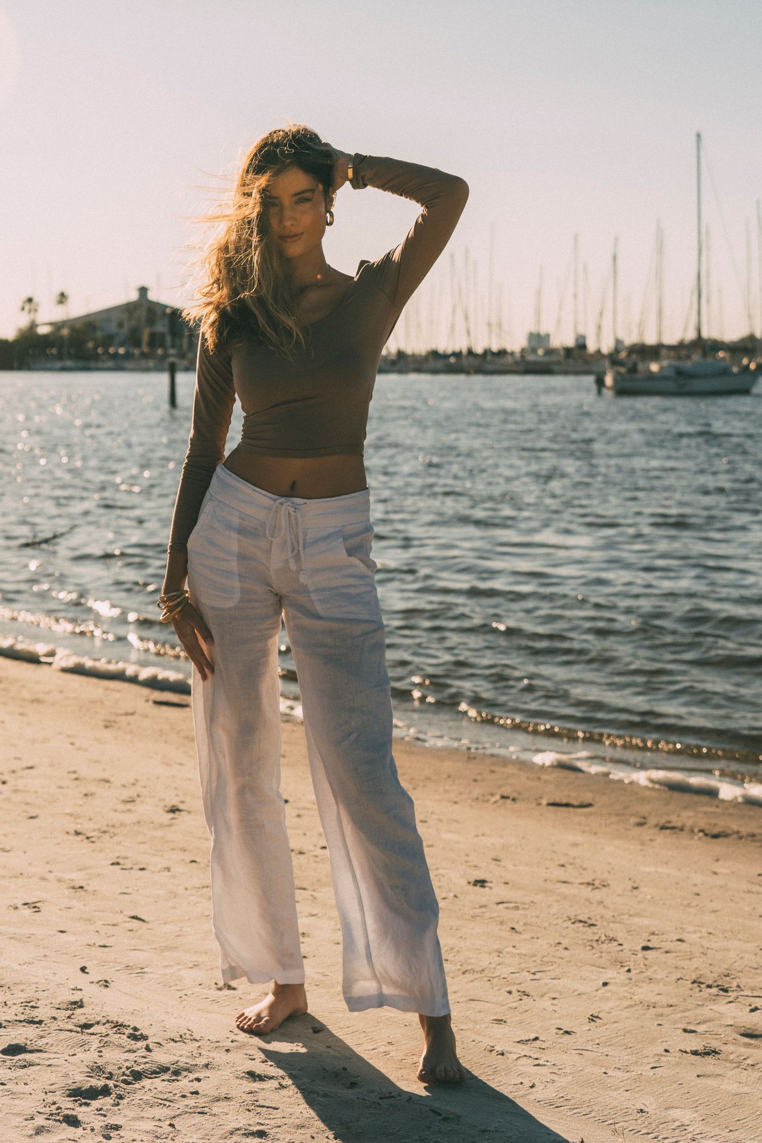 Model posing in designer outfit on Tampa beach during golden hour fashion photoshoot
