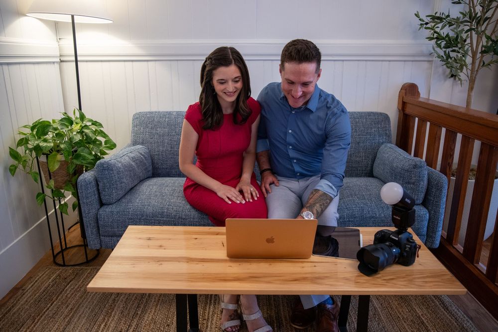 Couple reading contract documents and reviewing paperwork together at wooden dining table.