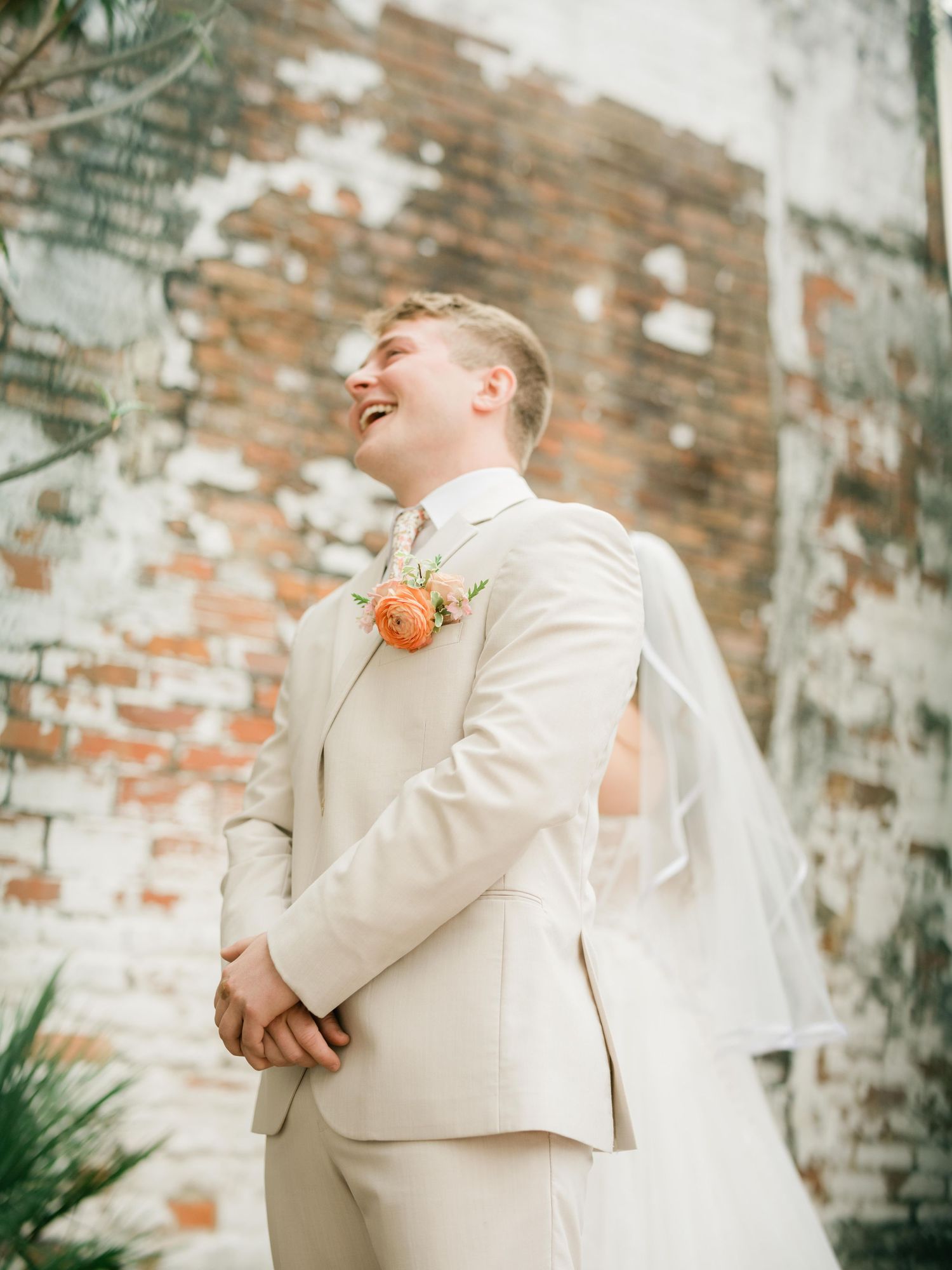 Wedding celebration at rustic brick venue with lush greenery and light decor.