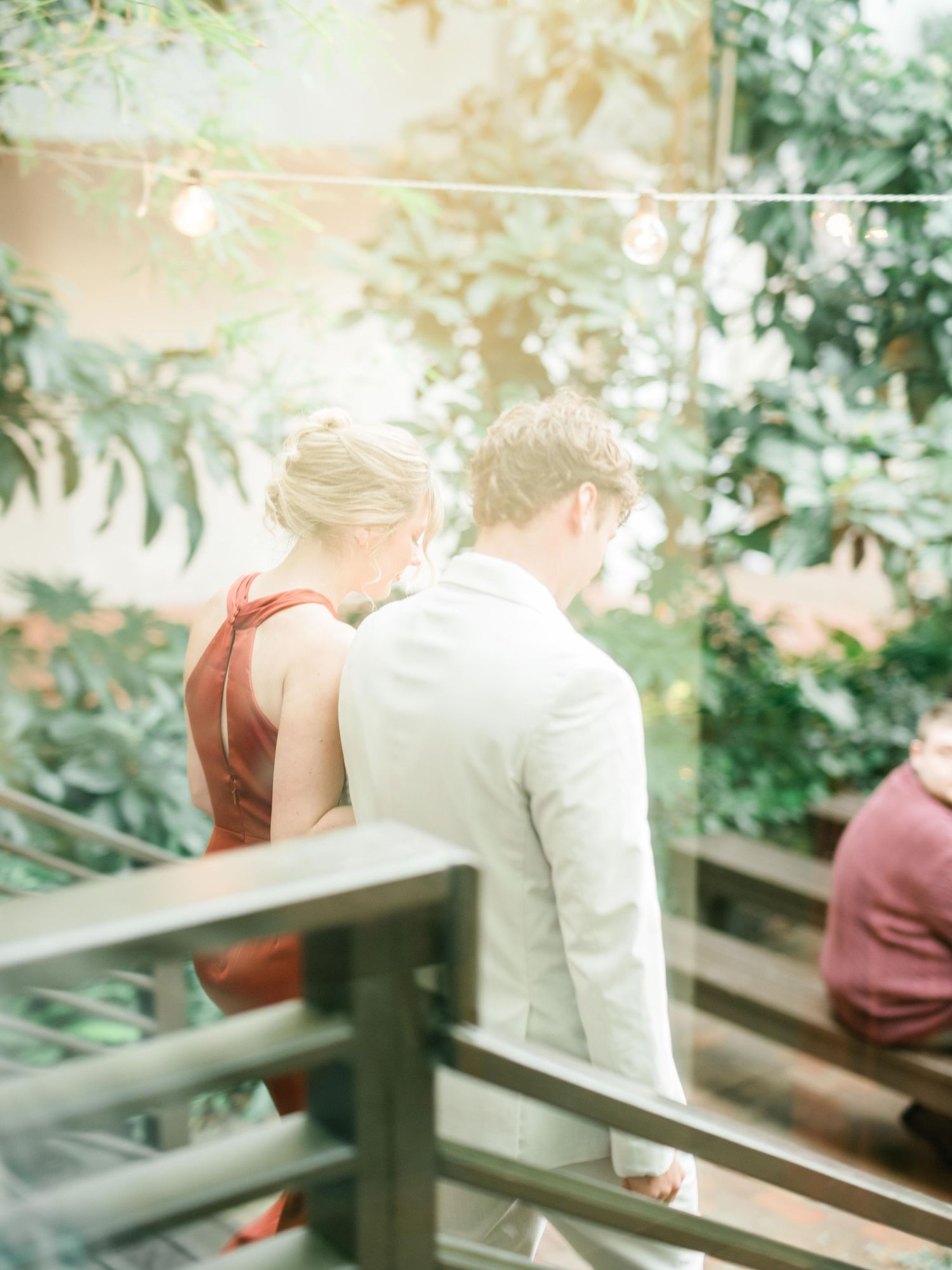 Guests enjoy a quiet moment on an outdoor terrace with string lights overhead.