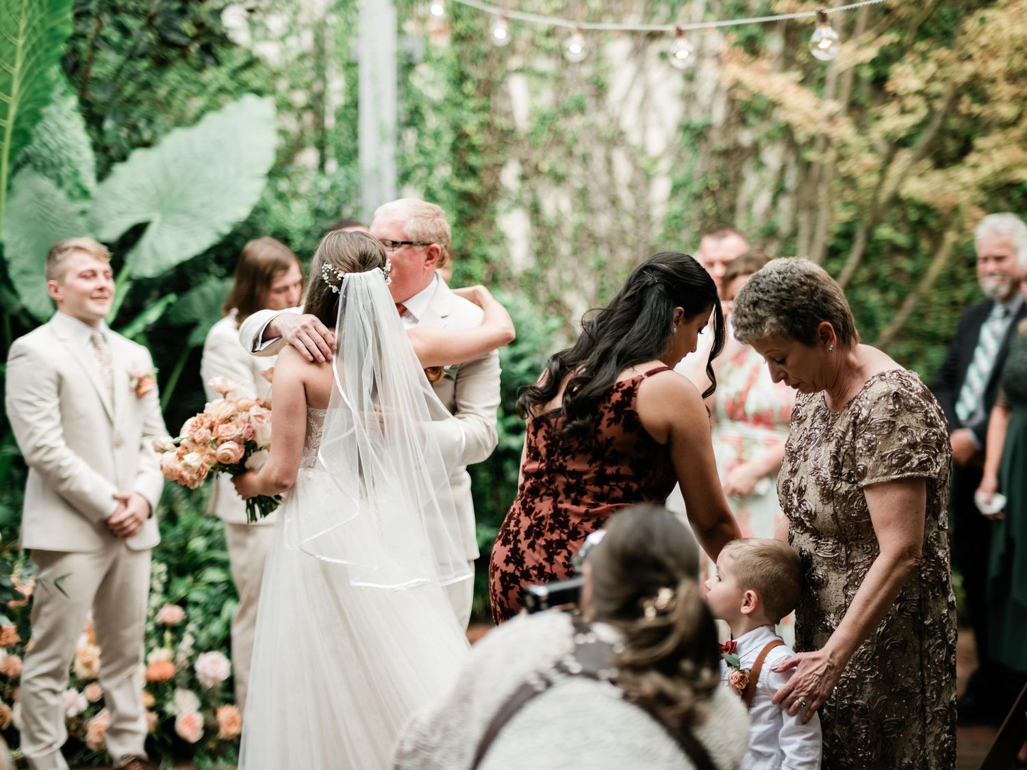 Intimate garden wedding ceremony surrounded by lush greenery and natural decor.