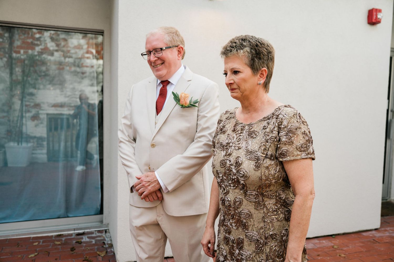 A couple in formal attire standing together at a wedding venue.