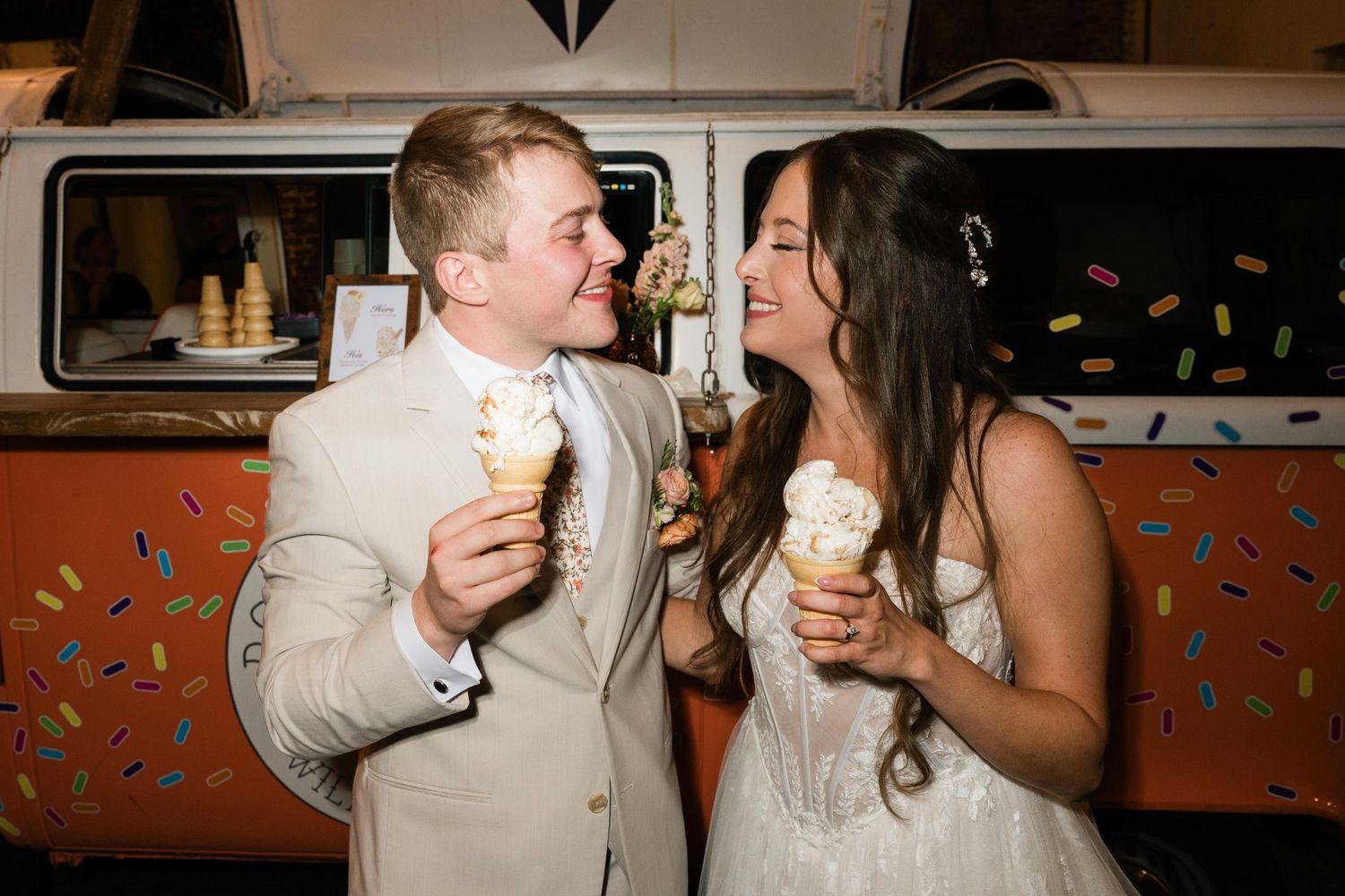 Happy couple enjoying ice cream cones together against vintage food truck backdrop.