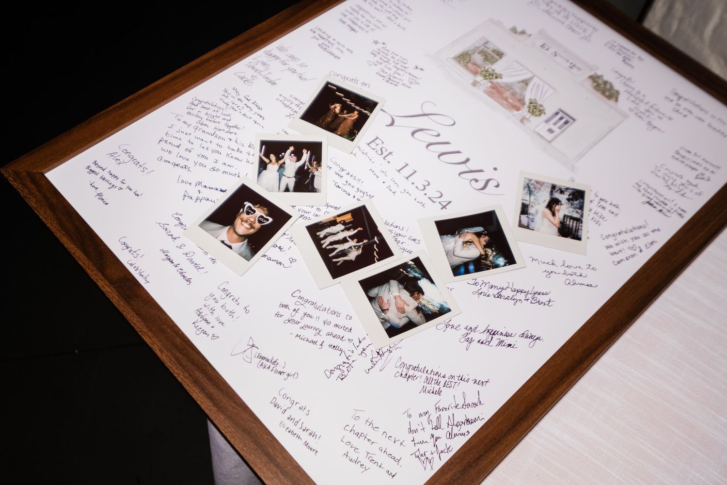 A wedding guestbook with multiple black and white photographs scattered across white pages with handwritten messages.