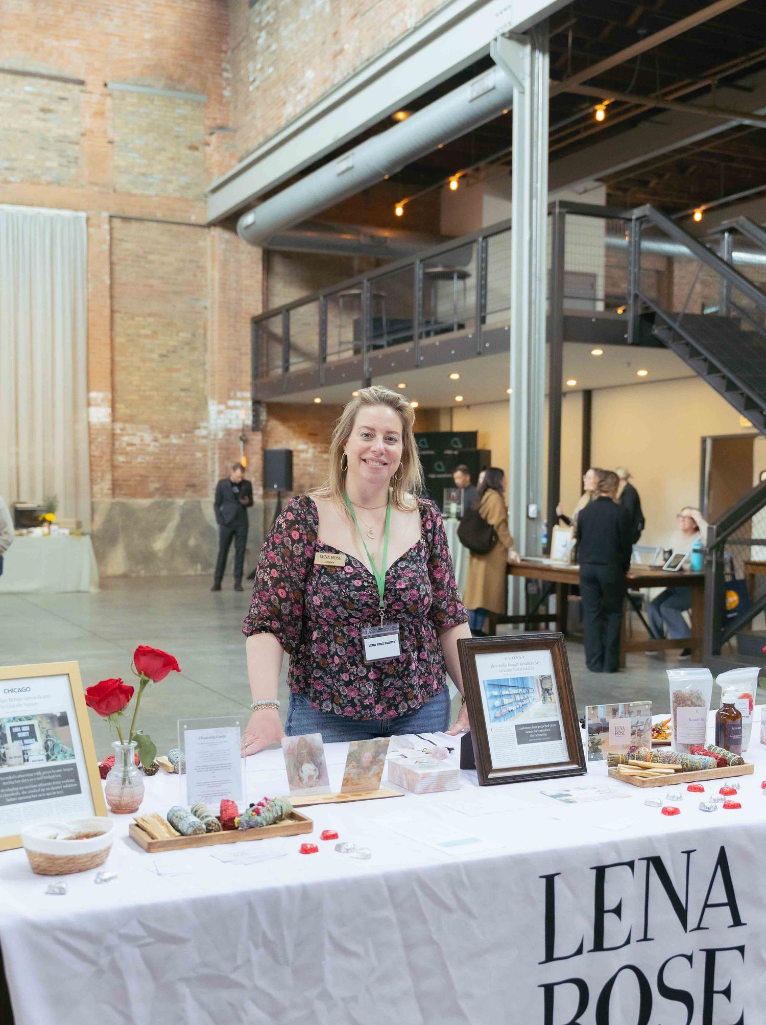 Vendor booth displays artisanal food products on white tablecloth at industrial venue event. At Fairlie, Chicago