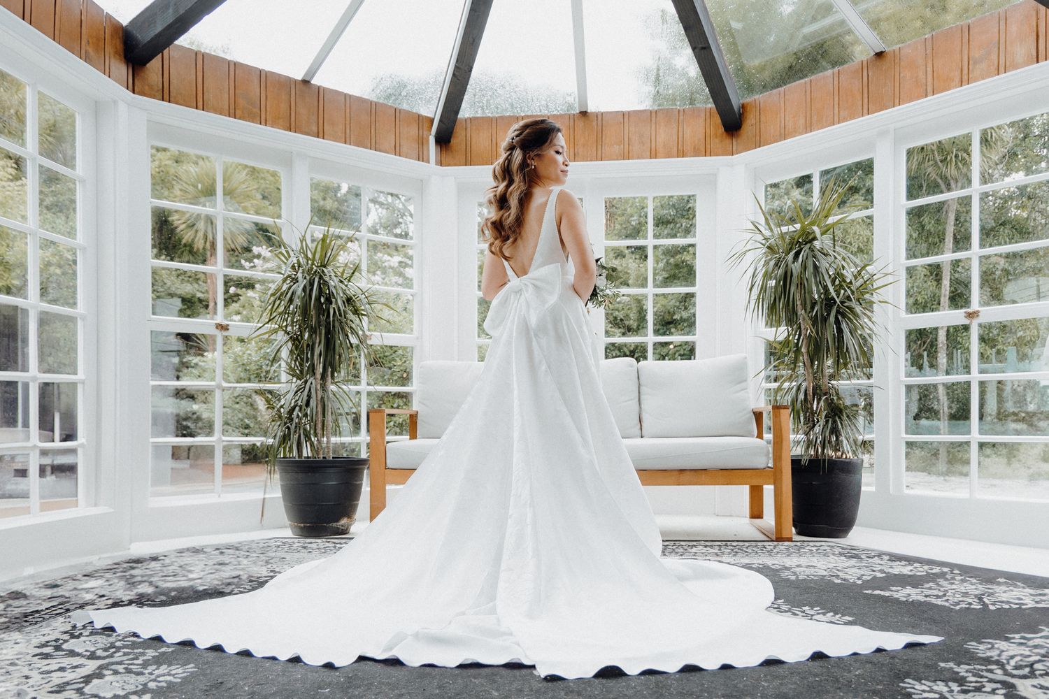 A bride in a flowing white wedding gown with a long train captured by Apertured Media Auckland Wedding Photographer.