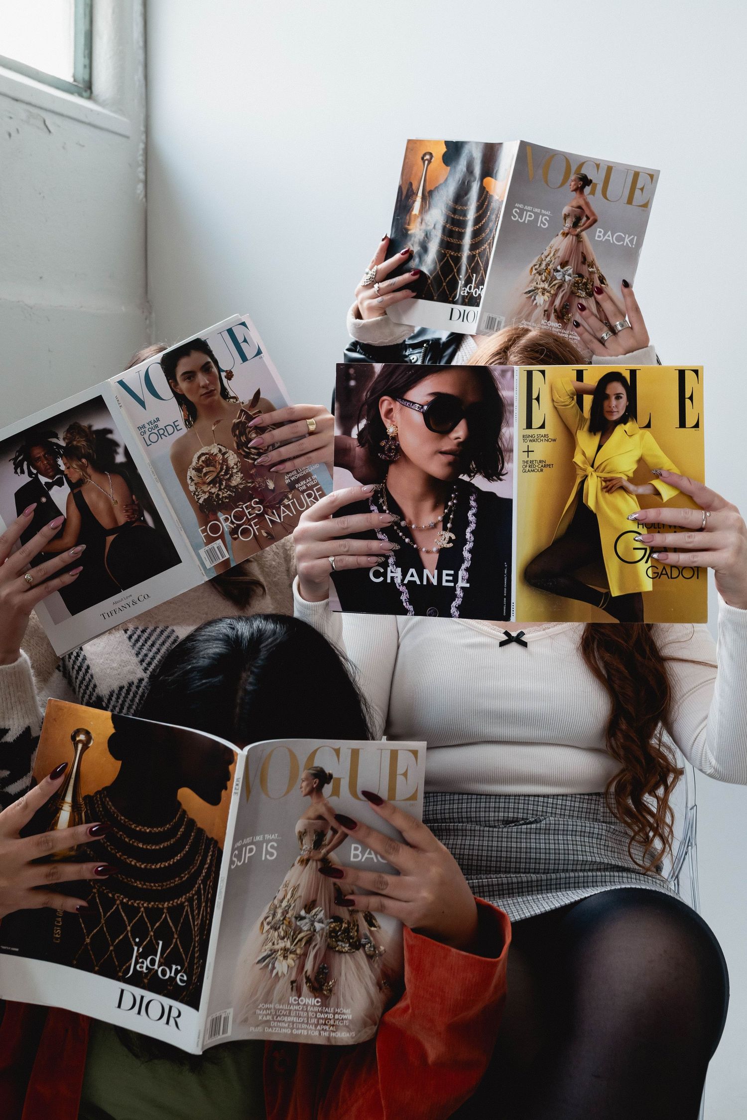 Fashion magazines spread out showing luxury brand covers and editorial pages.