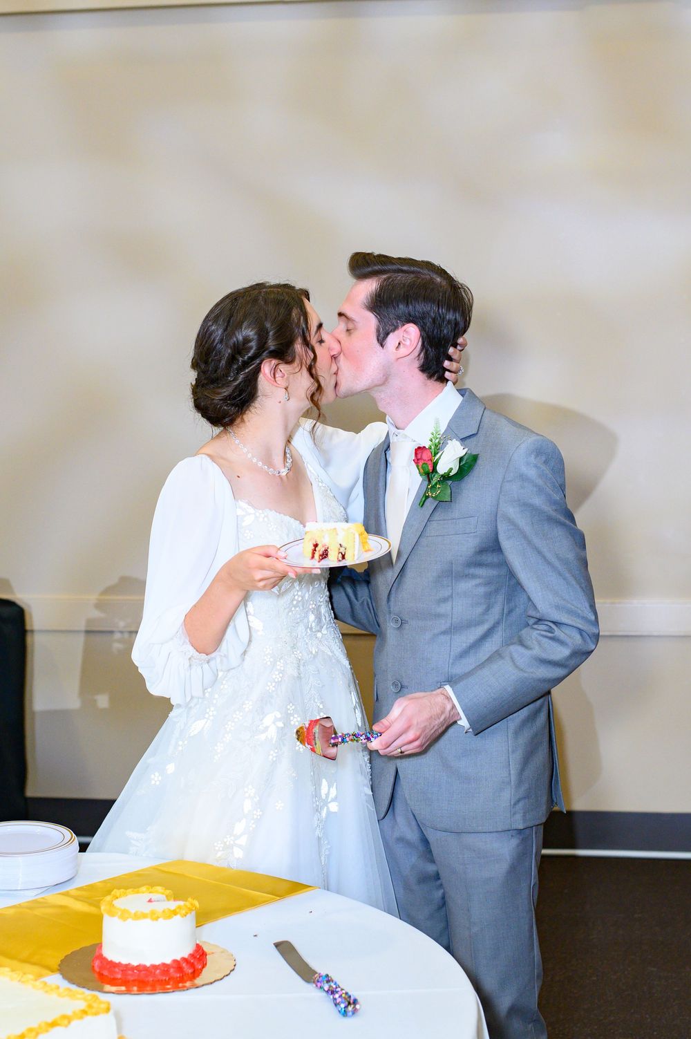 A wedding couple shares a sweet moment while cutting their cake together at the reception.