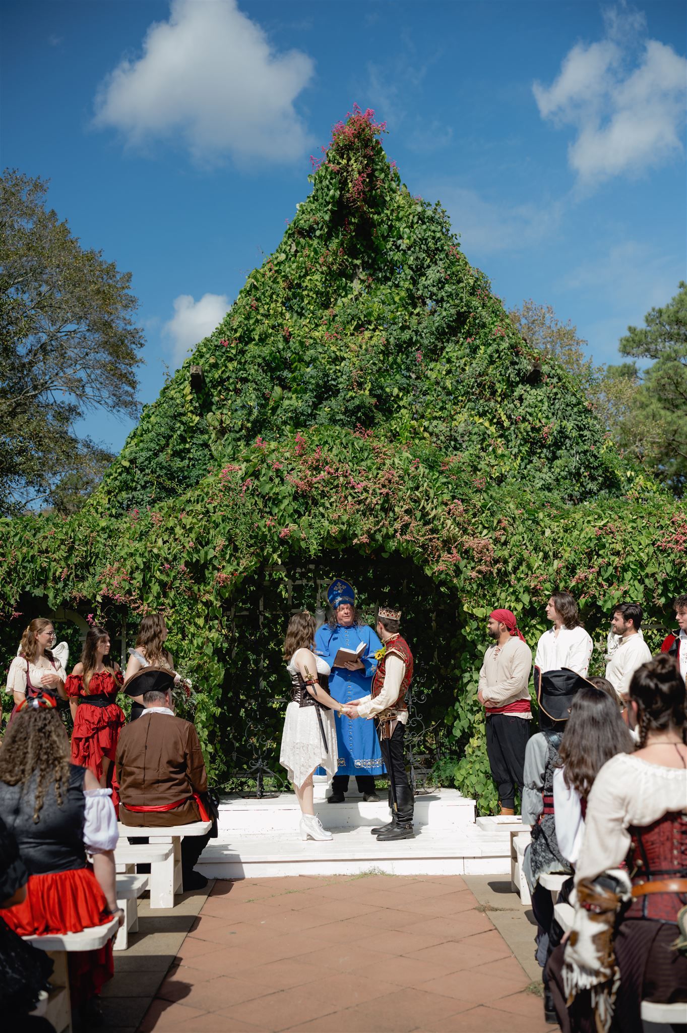 A sequence showing a garden archway entrance decorated with climbing vines and flowers as guests gather for an outdoor event.