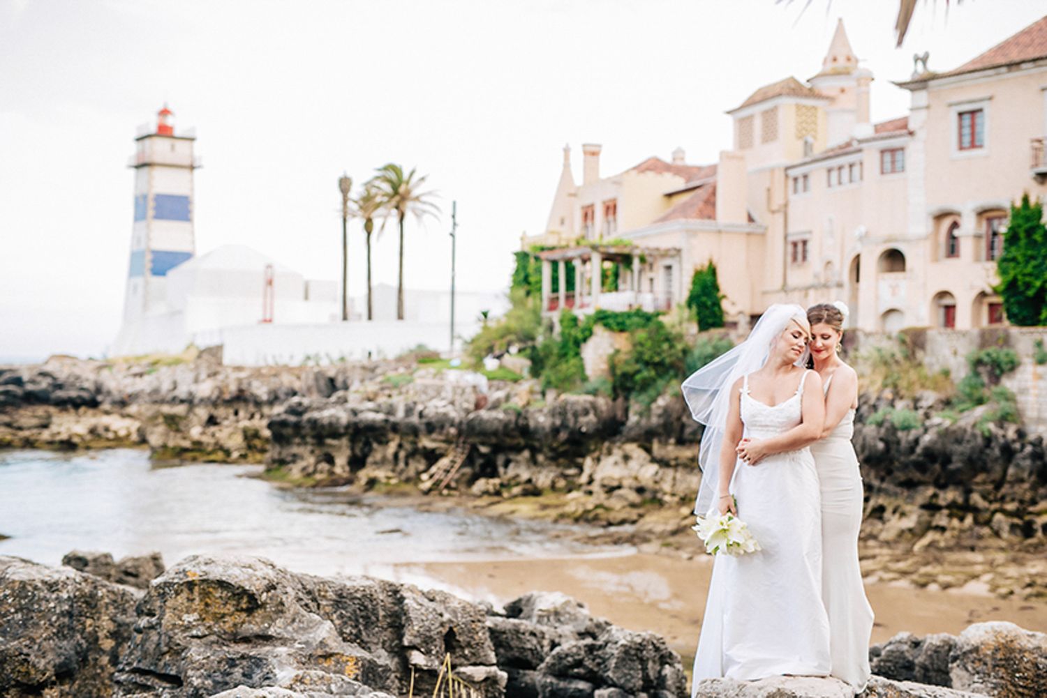 romantic embrace of a gay/lesbian couple on their destination wedding in Portugal at the beach. captured by a Lisbon wedding photographer.