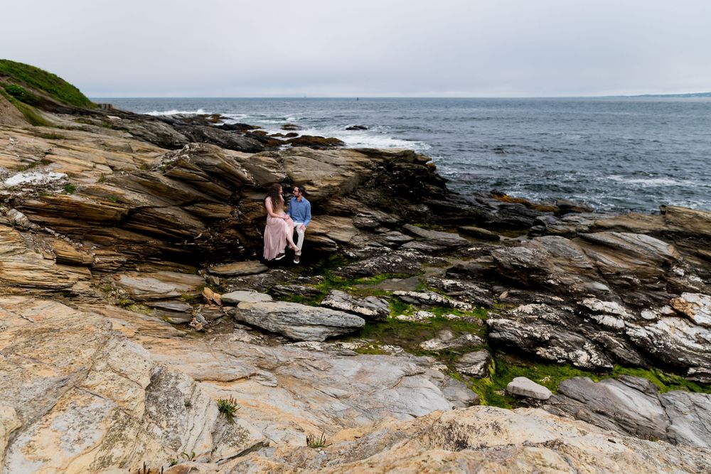 Rocky coastal cliffs along the ocean shoreline with dramatic layered rock formations and crashing waves.