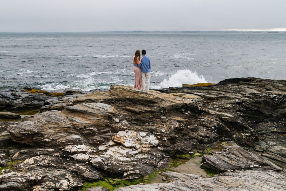 Ocean waves crash against dramatic rocky coastline during foggy weather at Mosselbaai in South Africa.