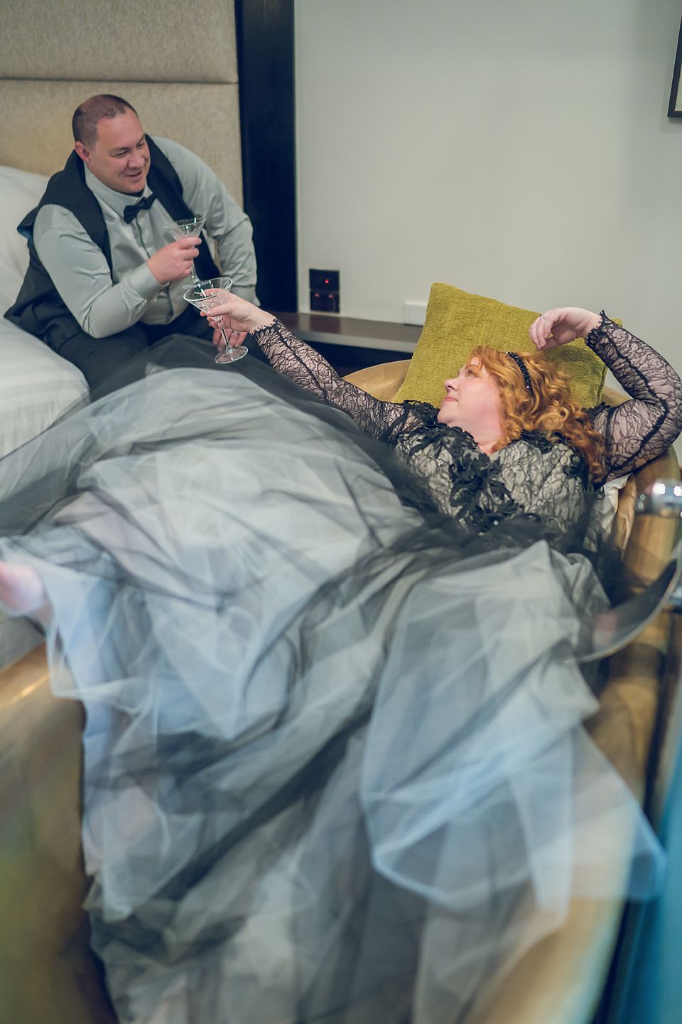 Person in grey sweater rests on a couch with a flowy tulle blue dress draped across.