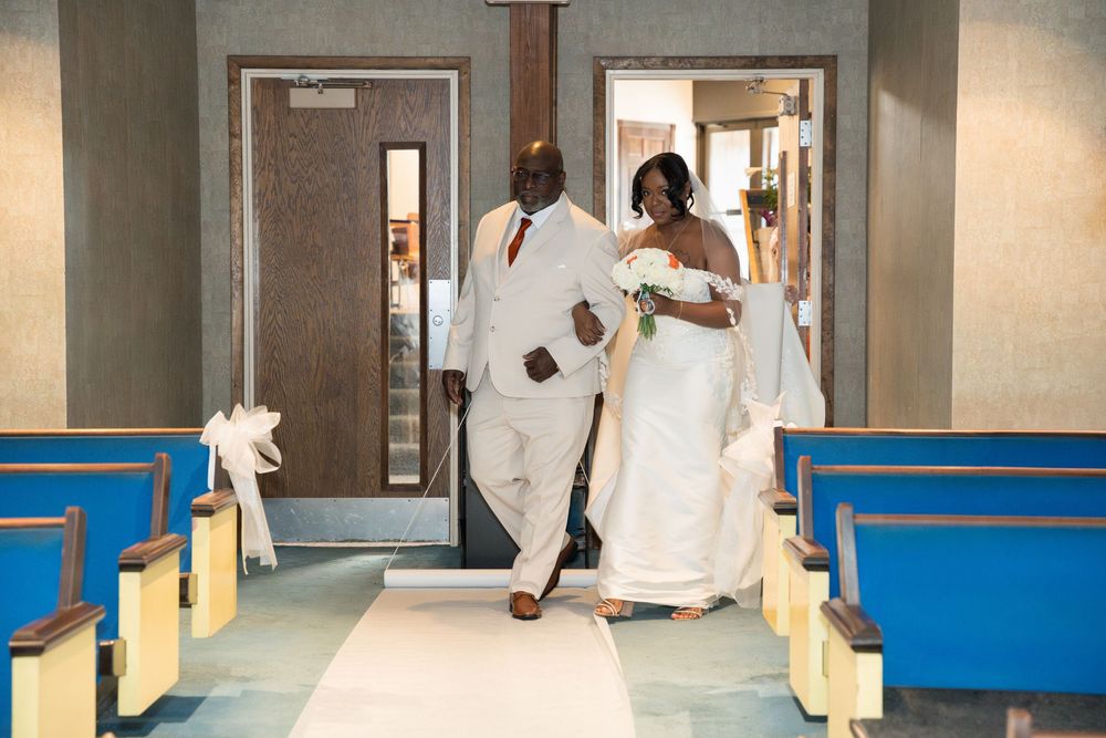 Medical professionals in white coats walk through a hospital hallway with blue walls and yellow trim.