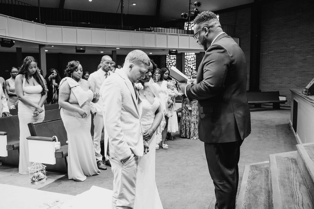 A vintage black and white photograph showing children in church clothing interacting with an adult figure at a service.