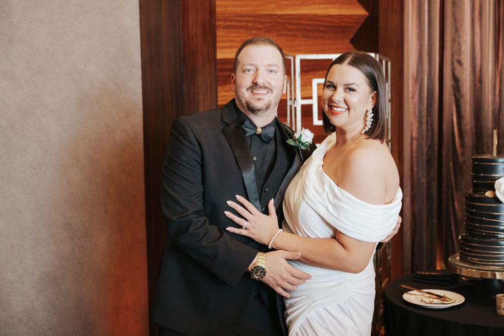 Joyful couple shares an intimate moment during their wedding celebration in a rustic wooden venue.