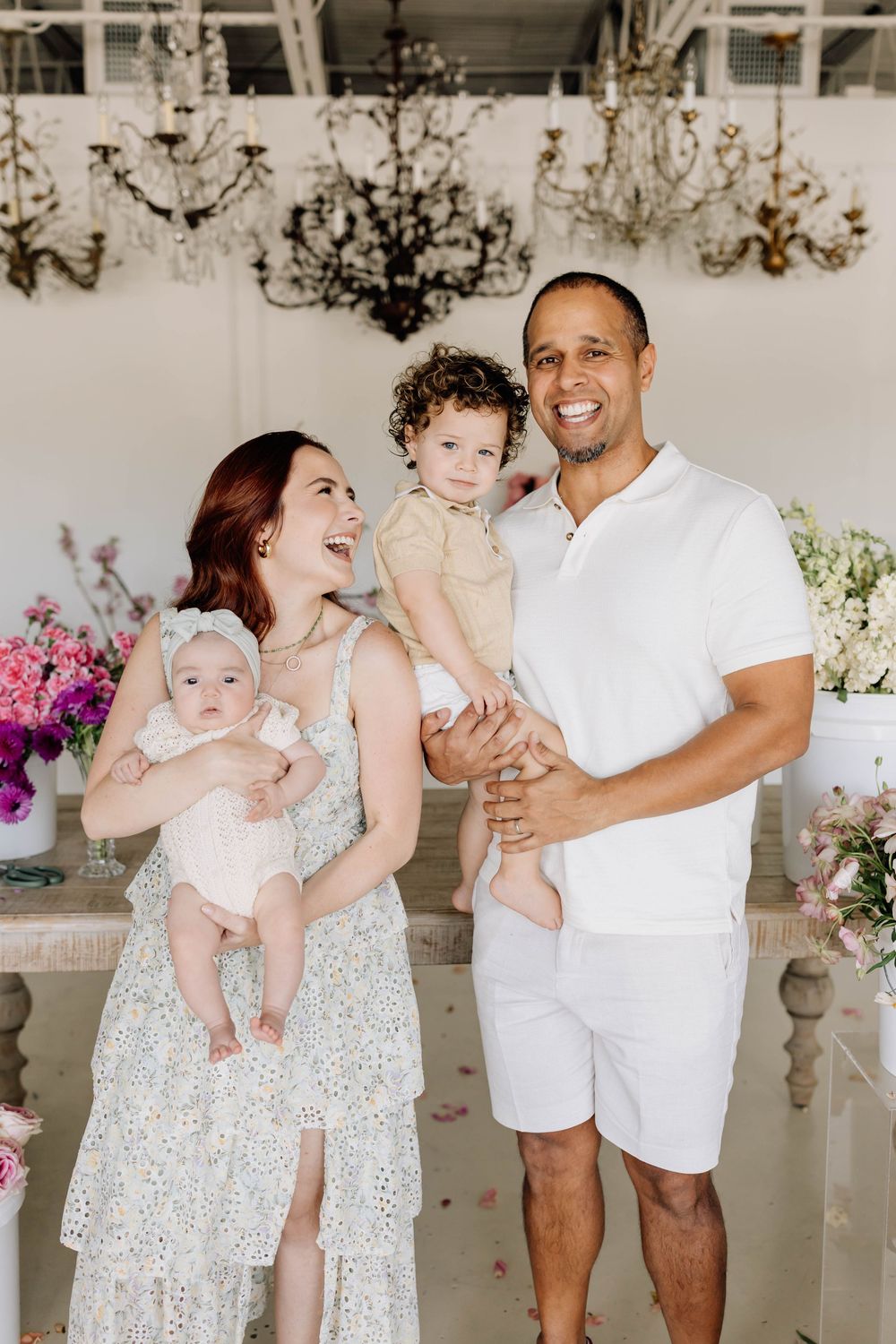 Five sequential photos showing a family in white outfits dancing and playing with a baby in a bright sun-lit room.