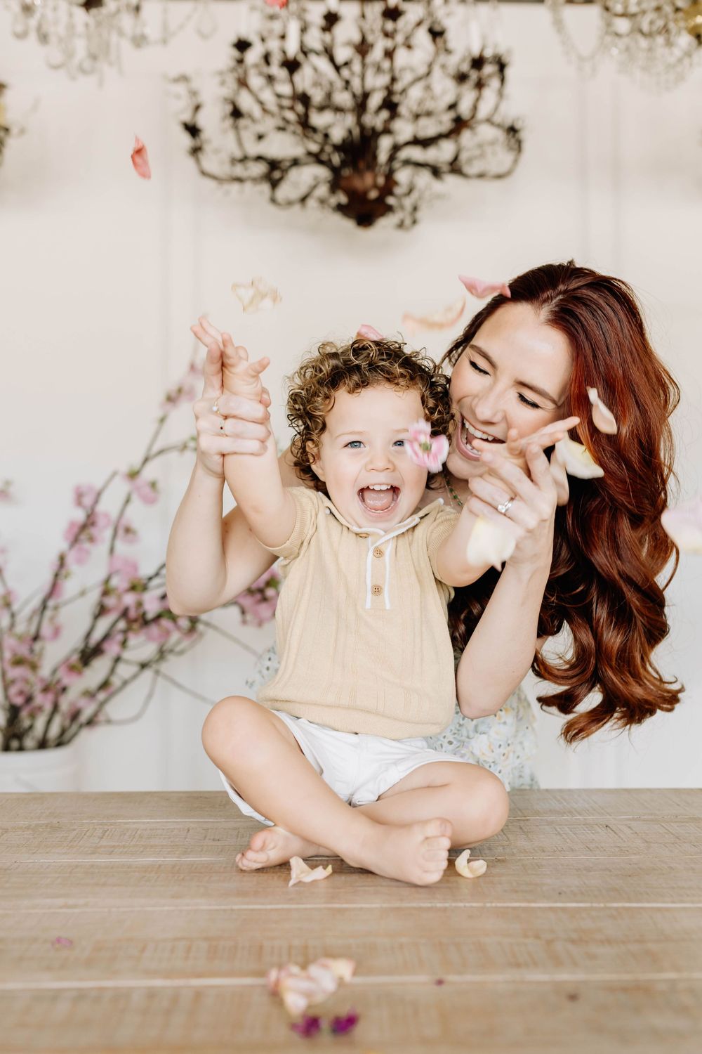 A playful moment captured on a wooden floor as two people share joyful laughter together.