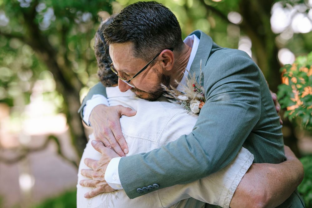 Emotional first look moment between wedding couple in a garden setting.