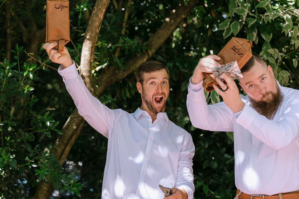 Wedding party celebrating with champagne sprays in a sunny garden.
