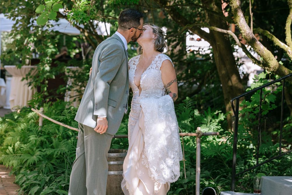 Bride and groom share an intimate moment while dancing together in a lush garden setting.
