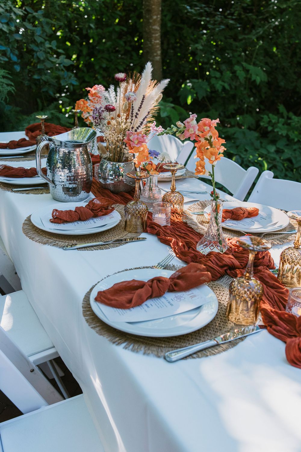 Elegant wedding table setting with terracotta accents and dried floral centerpieces.