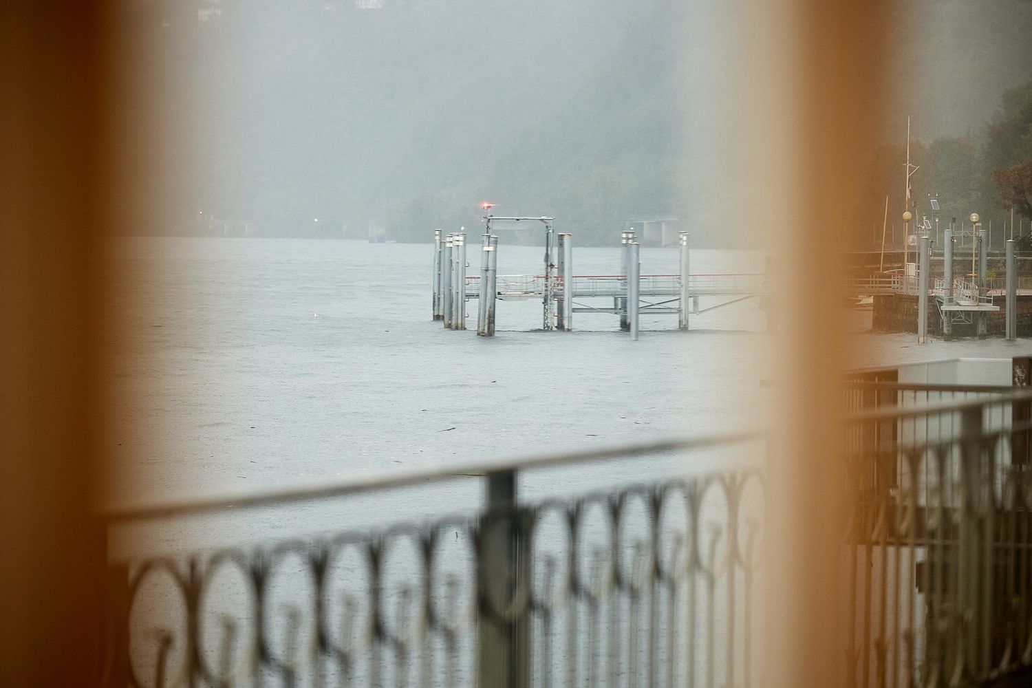 Foggy lake view with empty boat docks visible through window.