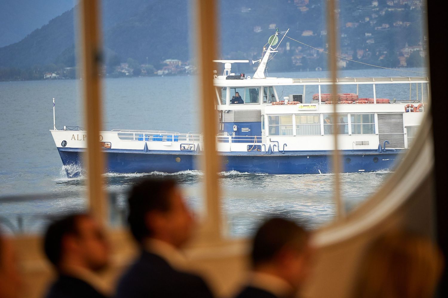 Ferry boat visible through window with mountain landscape in background.