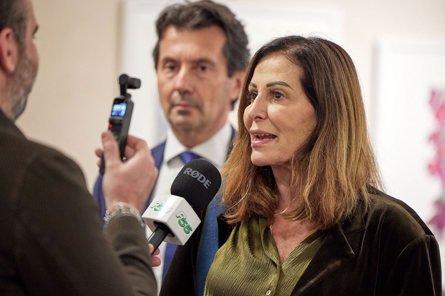 Media interview taking place at professional event with microphone.