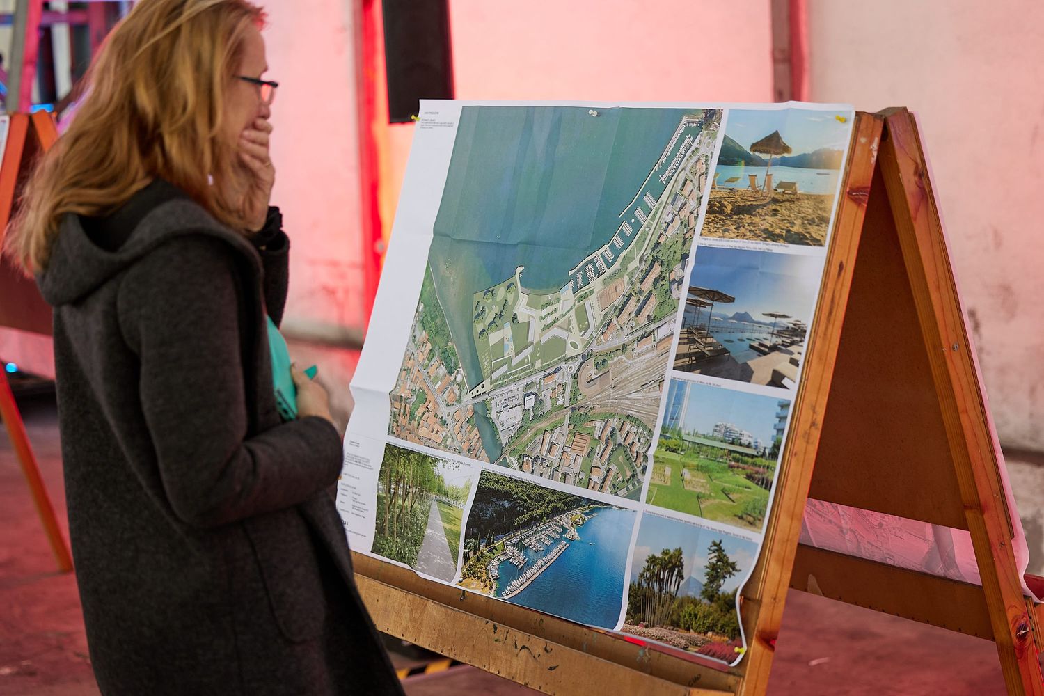 A person examining a promotional display board showing various scenic locations and landmarks.