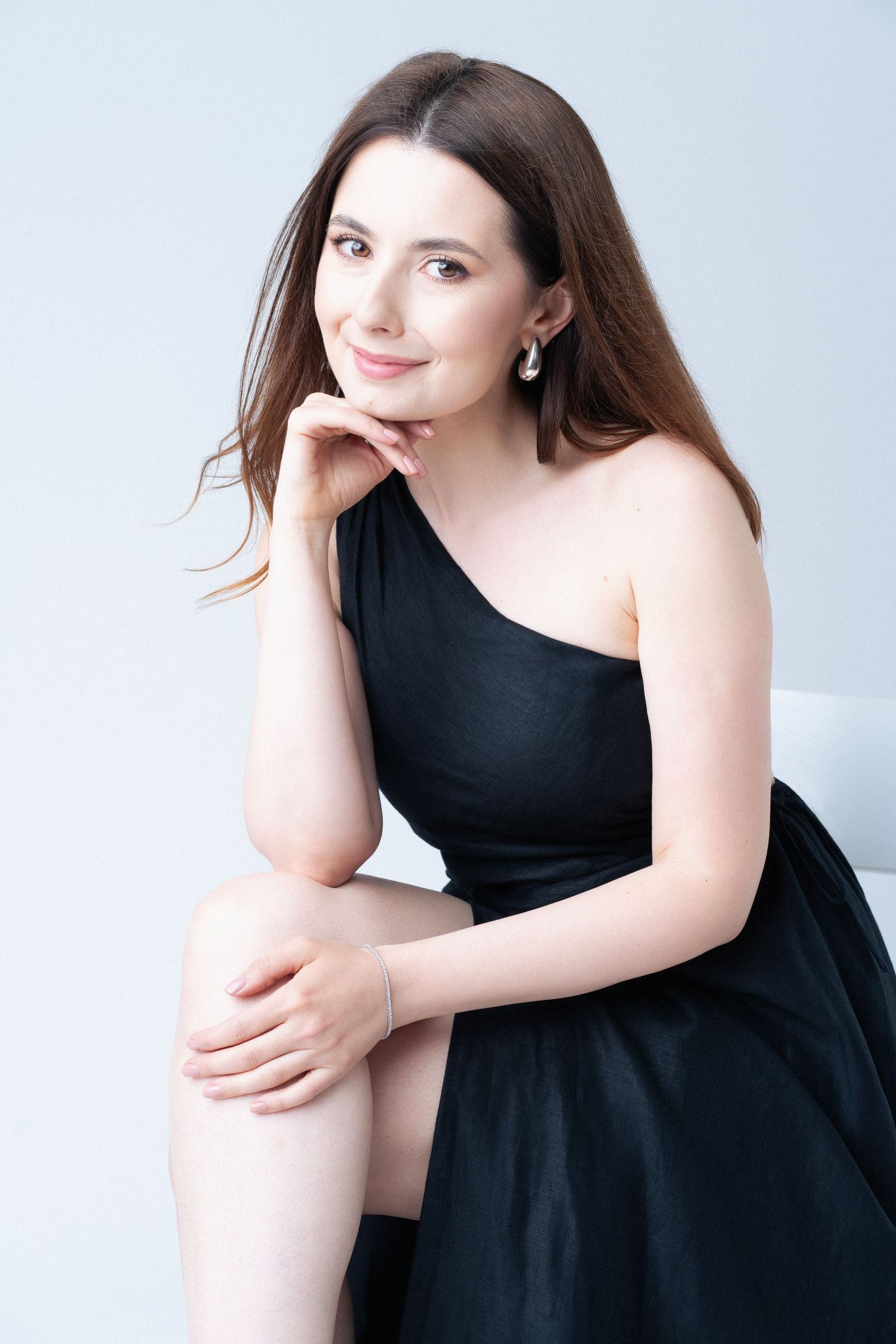 Portret profesional de studio cu femeie in rochie neagra, zambind natural