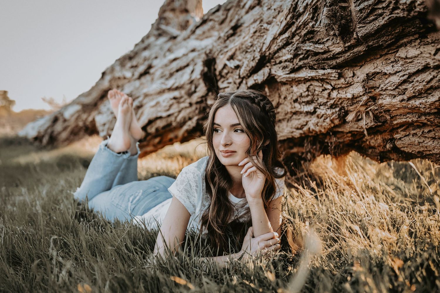 senior girl photos laying in the grass next to a tree in corinth taken by april pinto photography