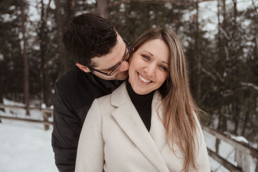 A romantic winter moment between a couple wearing dark and light coats in the snow.