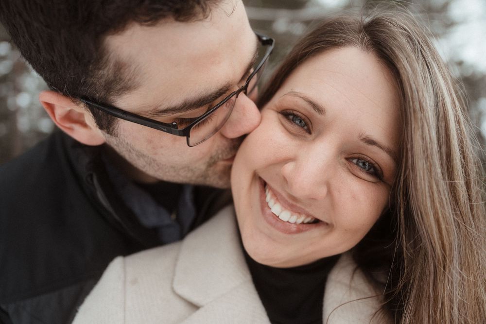 A tender moment between a couple during a winter photoshoot in the snow.