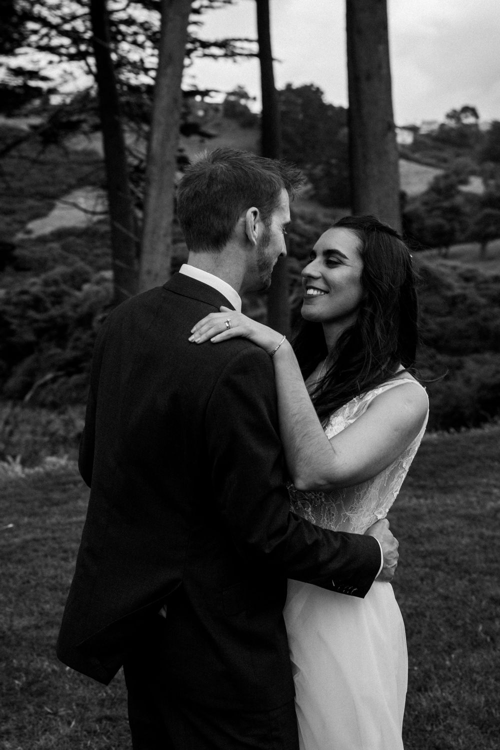 Intimate black and white portrait of couple embracing outdoors.
