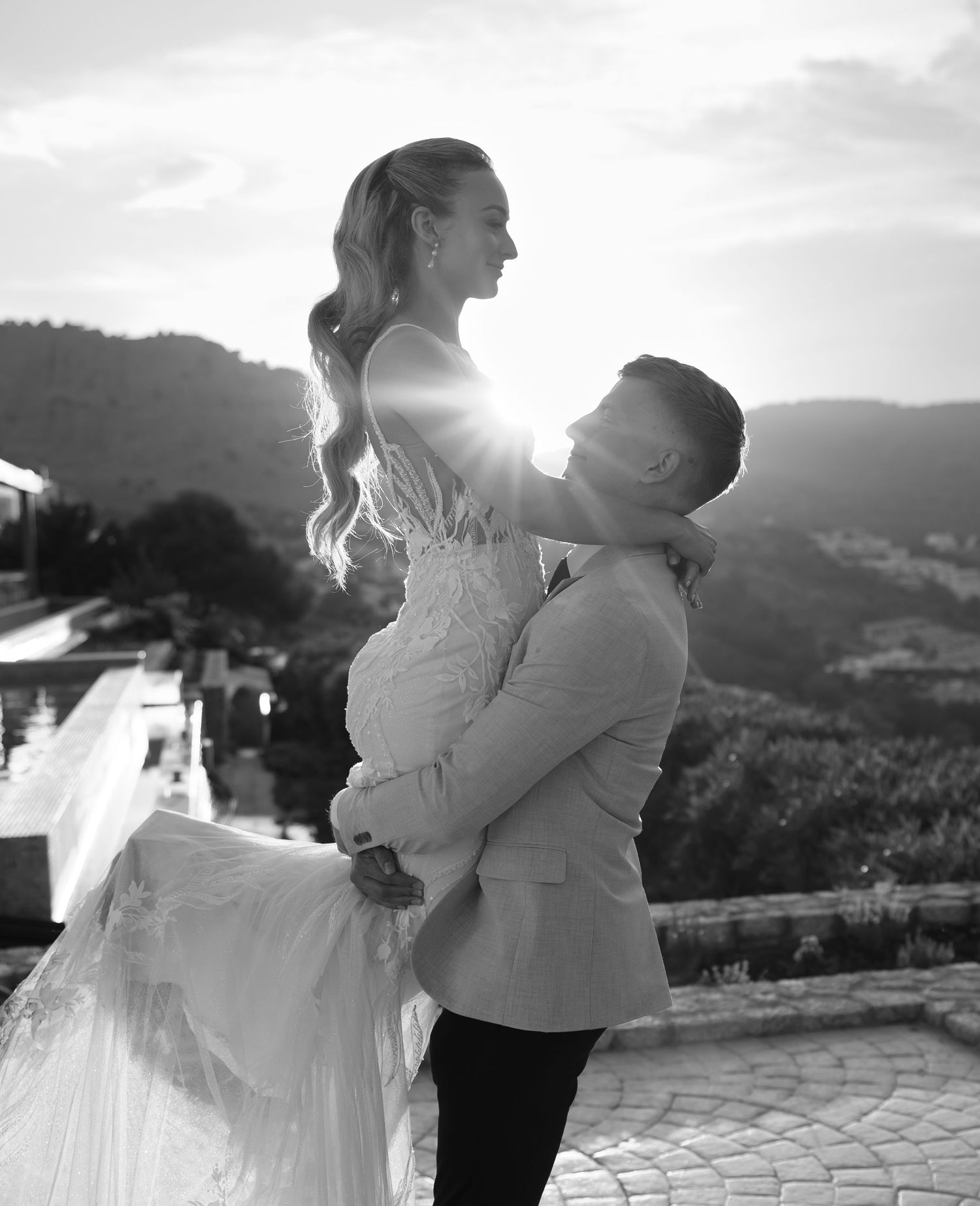 A romantic black and white photo sequence of a couple dancing and twirling at sunset with mountains in the background.