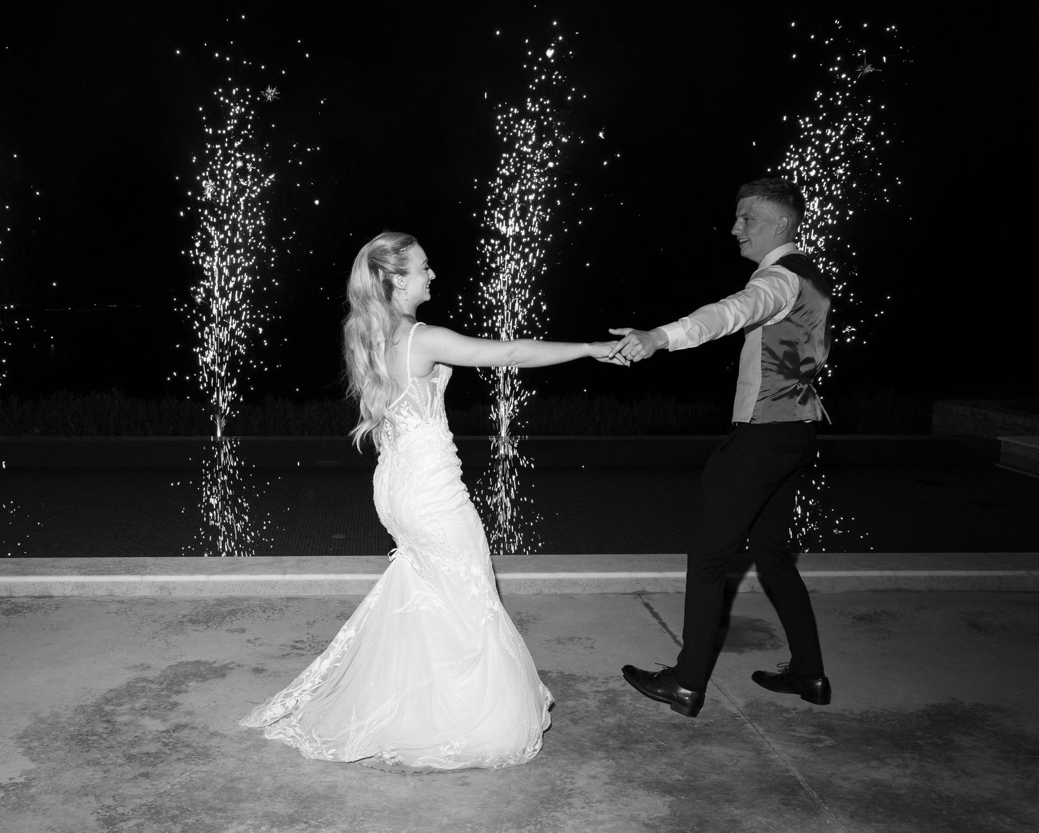 Elegant first dance sequence at a wedding reception showing the bride's dress twirling in black and white photography.