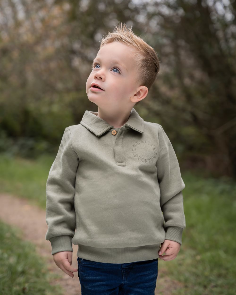 portretfoto van een jongen in een park, hij kijkt omhoog naar de zon. gebruik gemaakt van zachte en warme kleuren. in beneden-leeuwen