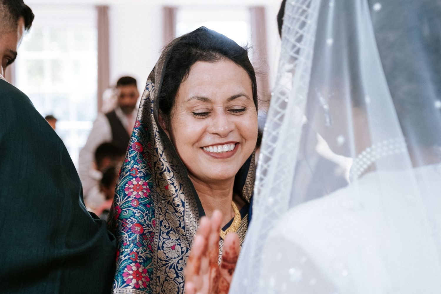 Muslim wedding guests smiling and speaking with the bride