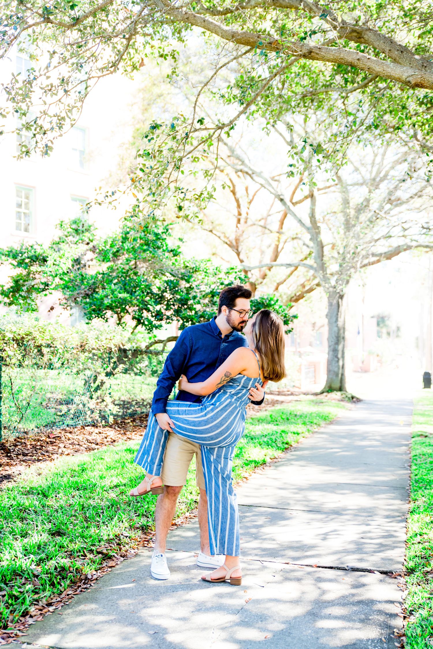 young man dipping and kissing young woman at Vinoy Park engagement photos in St. Pete, Florida