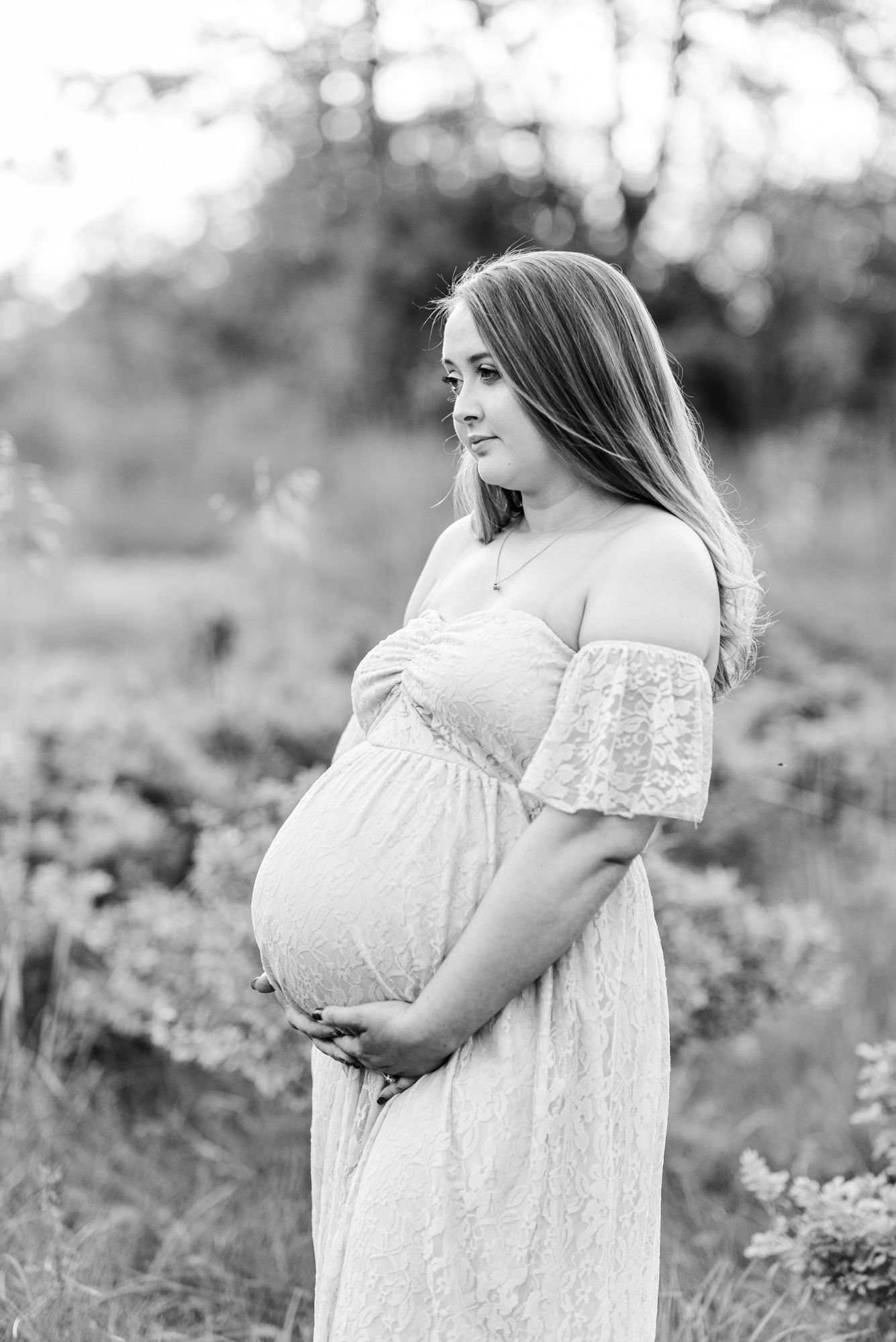 Maternity session with expecting mother in field in golden hour sunlight at Moraine State Park, Pennsylvania