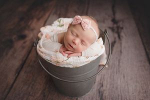 Baby girl in a bucket in a Perth newborn photography studio