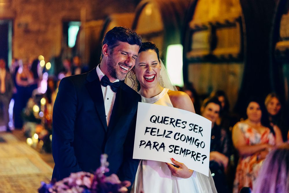 Quinta da Pacheca, adega, Casamento civil, noivos a rir noiva a segurar um cartaz, queres ser feliz comigo para sempre!