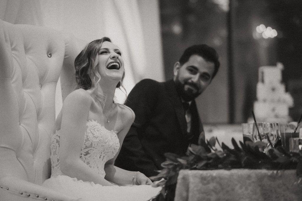 Bride and groom sharing a joyful moment during wedding reception dinner | Calgary wedding reception photography.