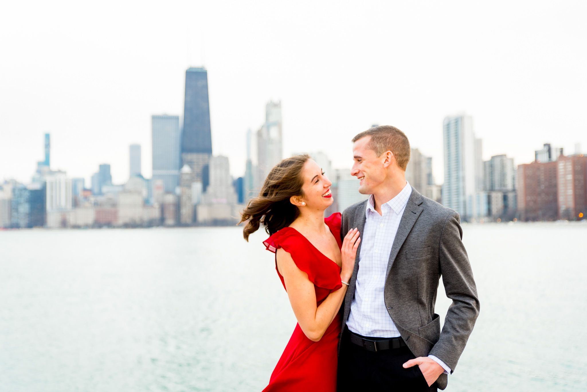 engaged couple looks at each other at North Avenue Beach engagement pictures on windy day